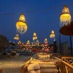 Elegant dinner setup under the stars in Agafay Desert with lanterns and traditional Moroccan decor.