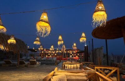 Elegant dinner setup under the stars in Agafay Desert with lanterns and traditional Moroccan decor.