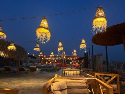 Elegant dinner setup under the stars in Agafay Desert with lanterns and traditional Moroccan decor.